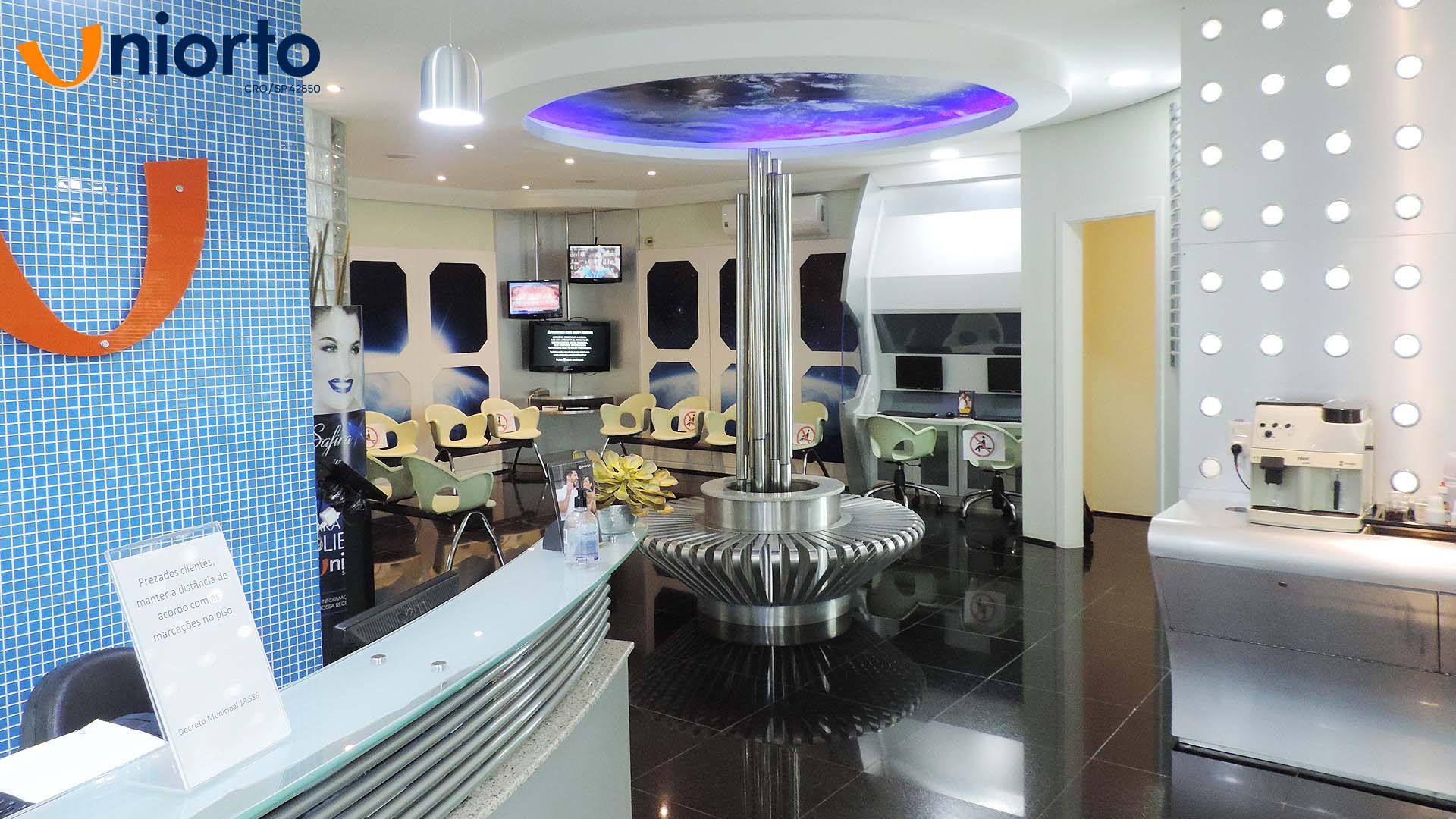 Sala de atendimento da Uniorto, com ambientação temática de galáxia nas paredes e no teto