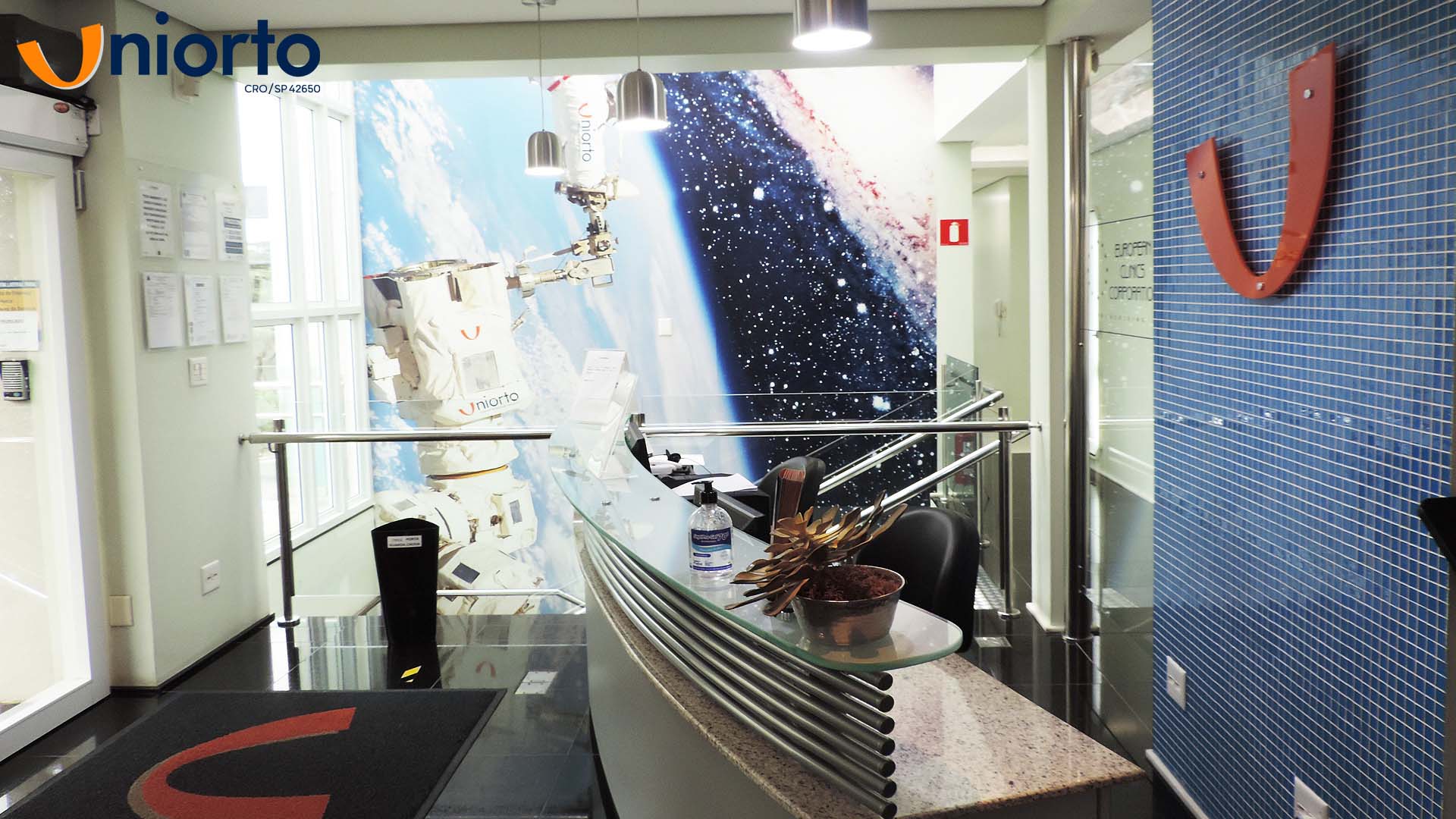 Sala de atendimento da Uniorto, com ambientação temática de galáxia nas paredes e no teto