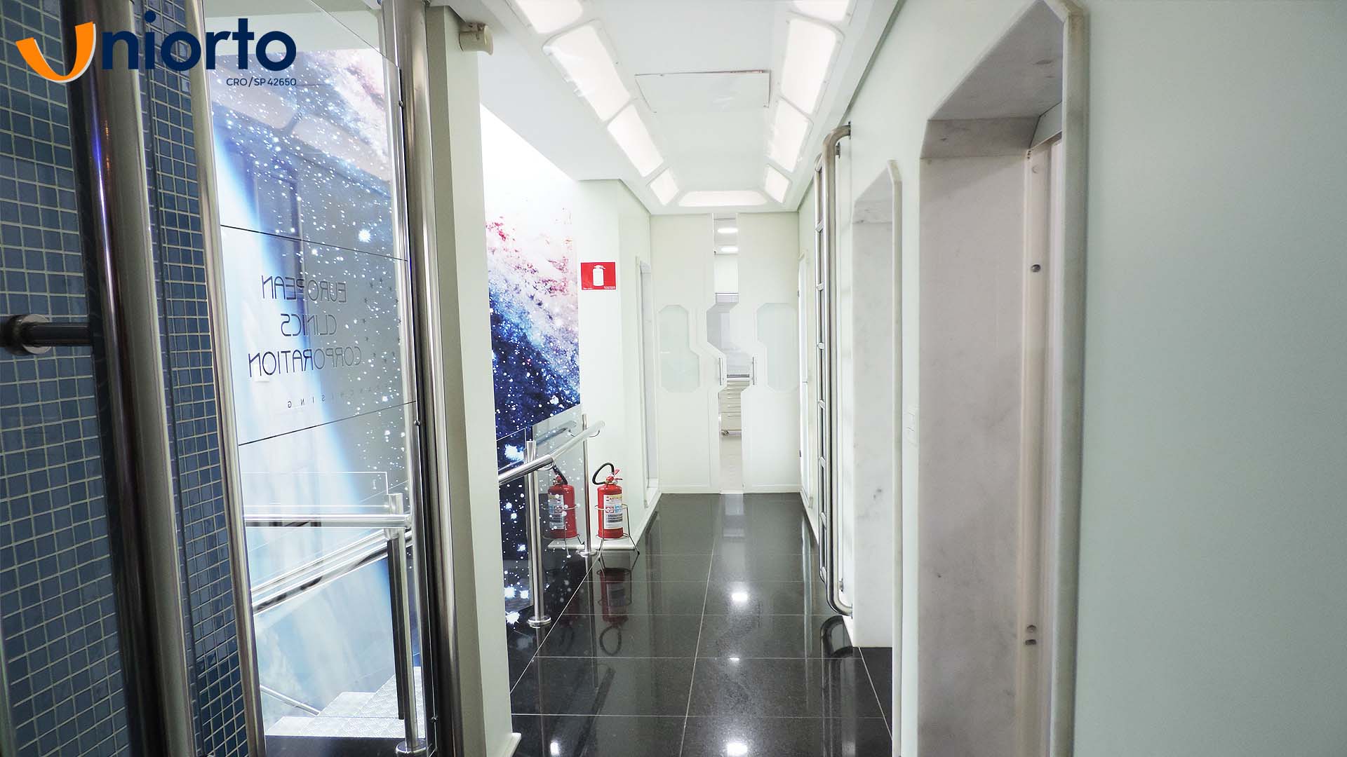 Sala de atendimento da Uniorto, com ambientação temática de galáxia nas paredes e no teto