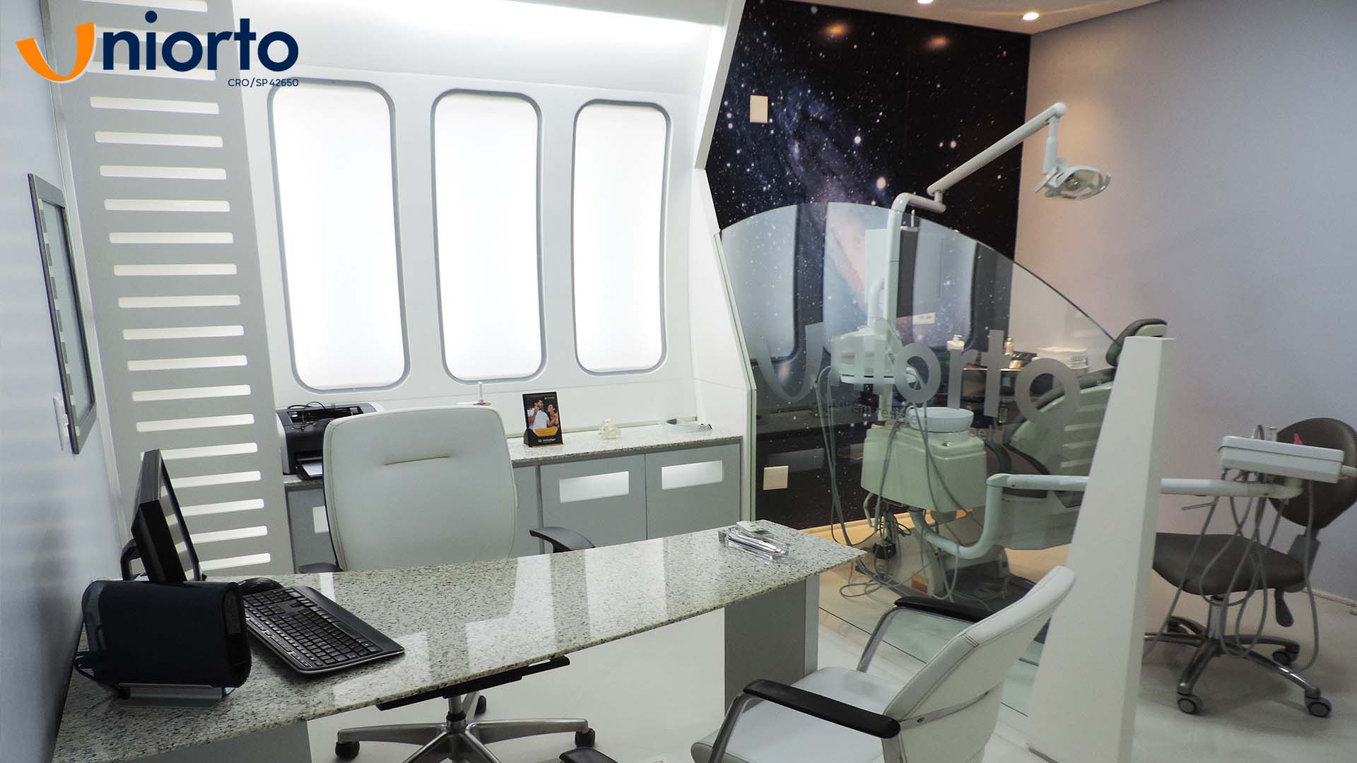 Sala de atendimento da Uniorto, com ambientação temática de galáxia nas paredes e no teto